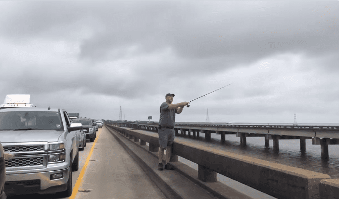A man fishing on a bridge