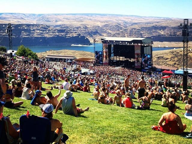 A crowd of people sitting on a hill overlooking Gorge Amphitheatre