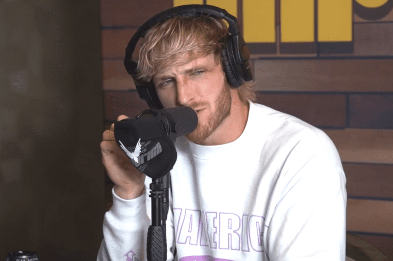 Logan Paul wearing headphones and holding a microphone