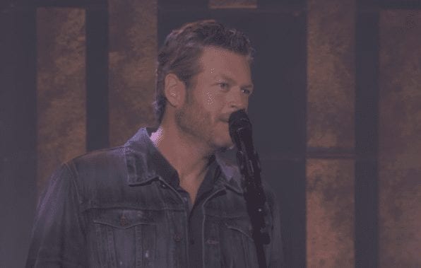 Blake Shelton with a beard and a mustache holding a microphone