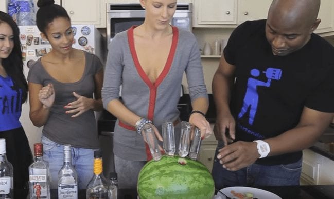 A group of people around a watermelon