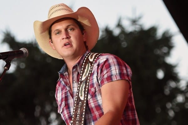 Jon Pardi with a cowboy hat singing into a microphone