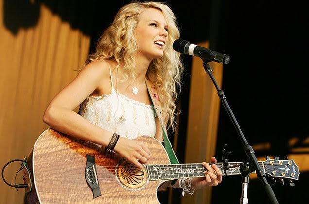 Taylor Swift playing a guitar