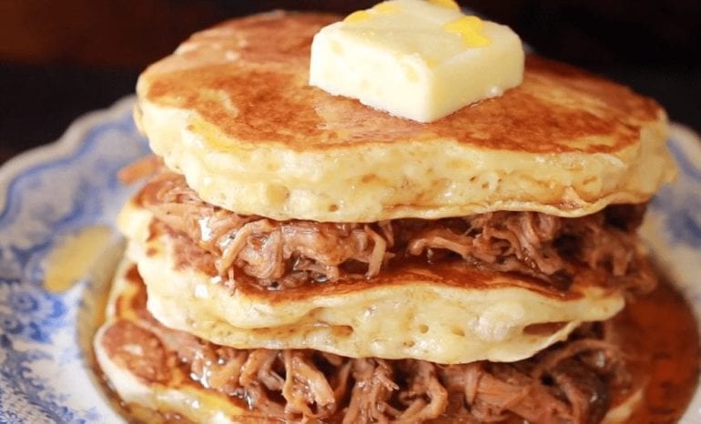 A stack of pancakes with bacon and cheese