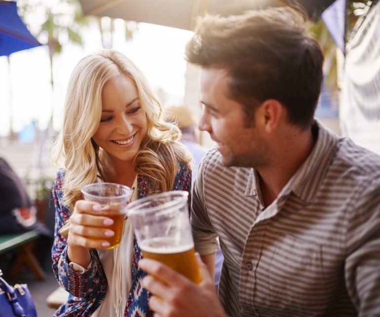 A man and woman holding glasses of beer