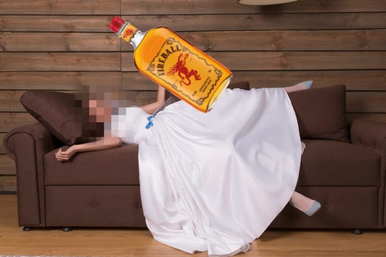 A person holding a bottle of alcohol