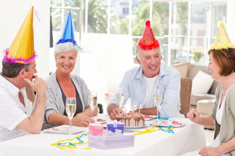 A group of people sitting around a table with party hats on