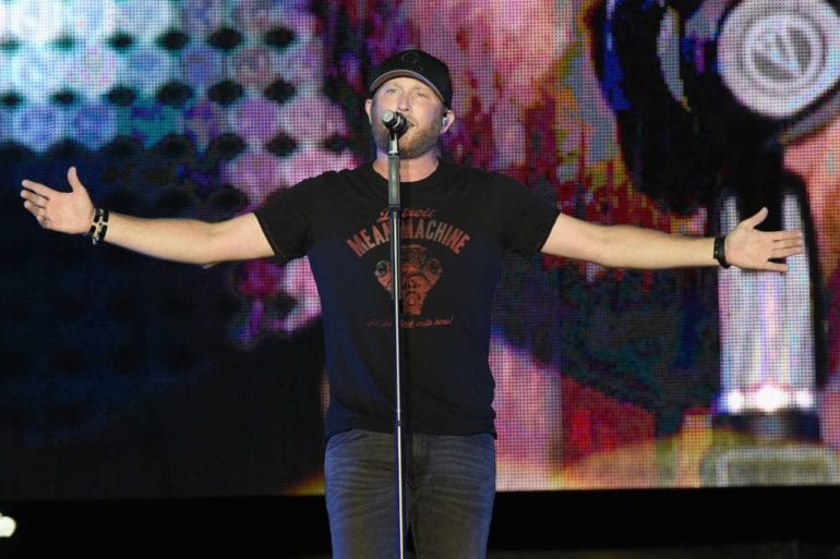 Cole Swindell on stage with a microphone