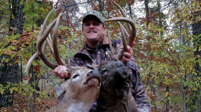 A man holding a large antlers