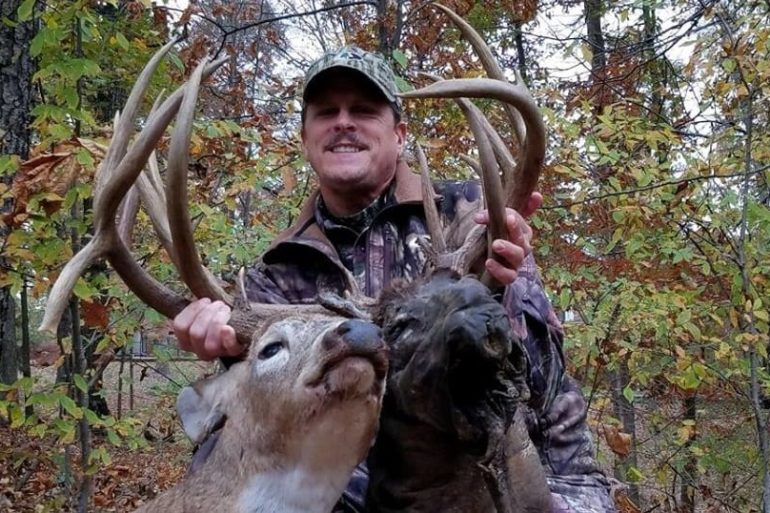 A man holding a large antlers