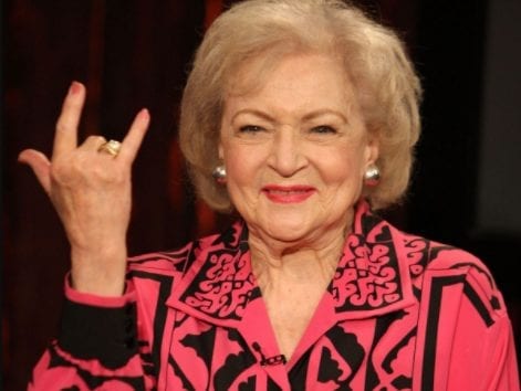 Betty White with her hand up