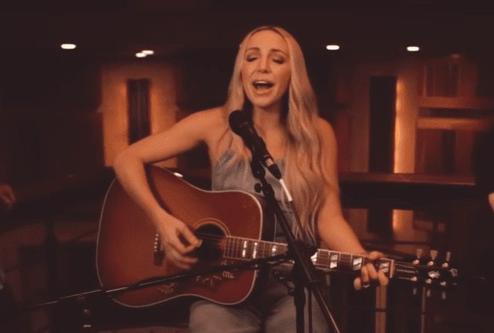 Ashley Monroe with long blonde hair playing a guitar