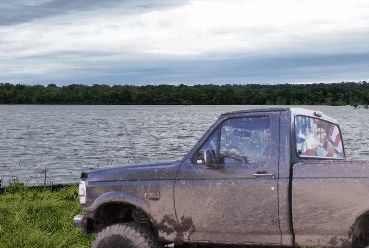 A truck parked by a lake