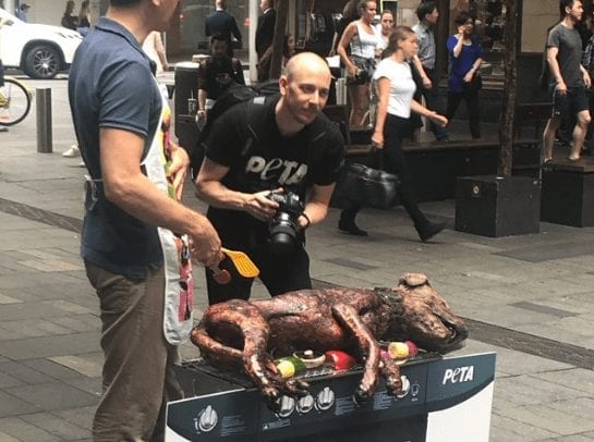 A person holding a large piece of meat on a grill