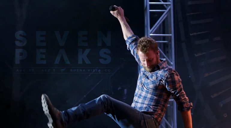 A man with a beard and a plaid shirt dancing on a stage