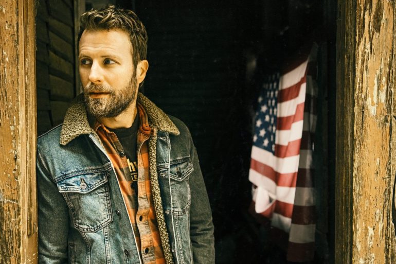Dierks Bentley standing in front of a flag