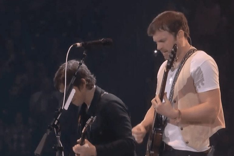 A person playing a guitar next to a person playing a guitar