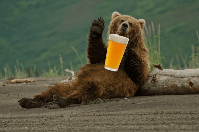 A bear holding a beer