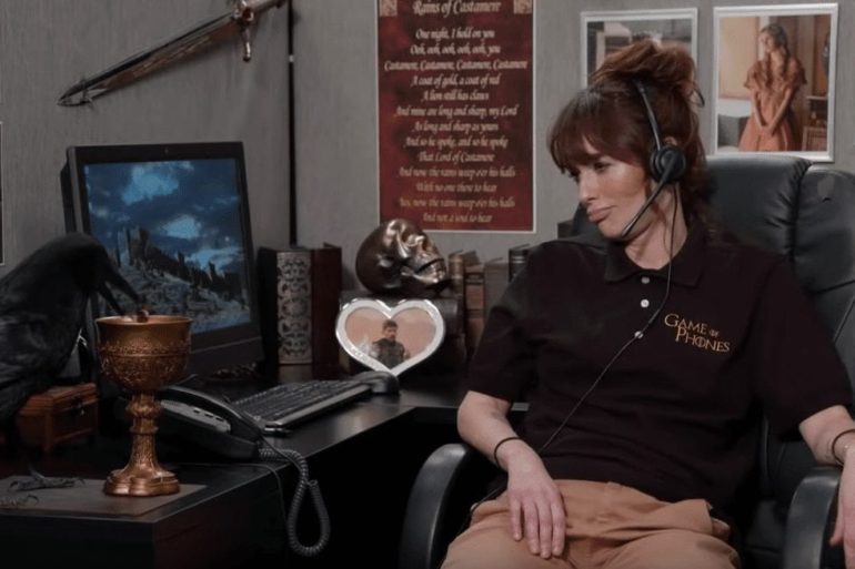 A person wearing headphones sitting at a desk with a computer and other objects