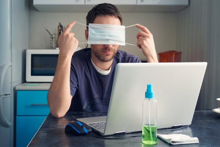 A person with a paper on the head and a laptop in front of him