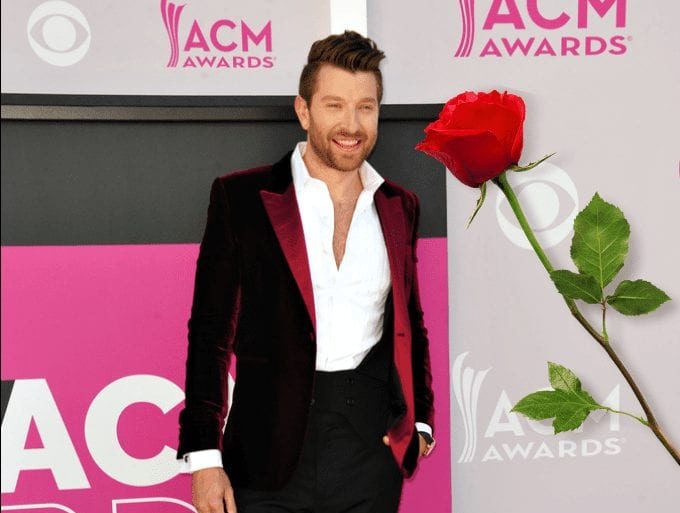 Brett Eldredge in a suit holding a rose
