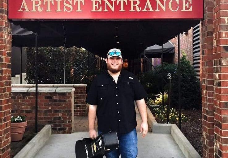 Luke Combs standing outside a building