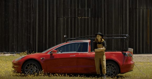 A person standing next to a red car