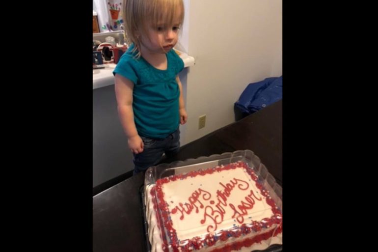 A child standing in front of a cake