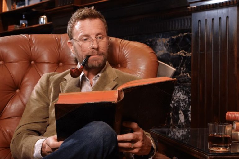 Dierks Bentley sitting on a couch reading a book