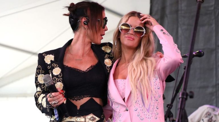 Two women with sunglasses and a microphone