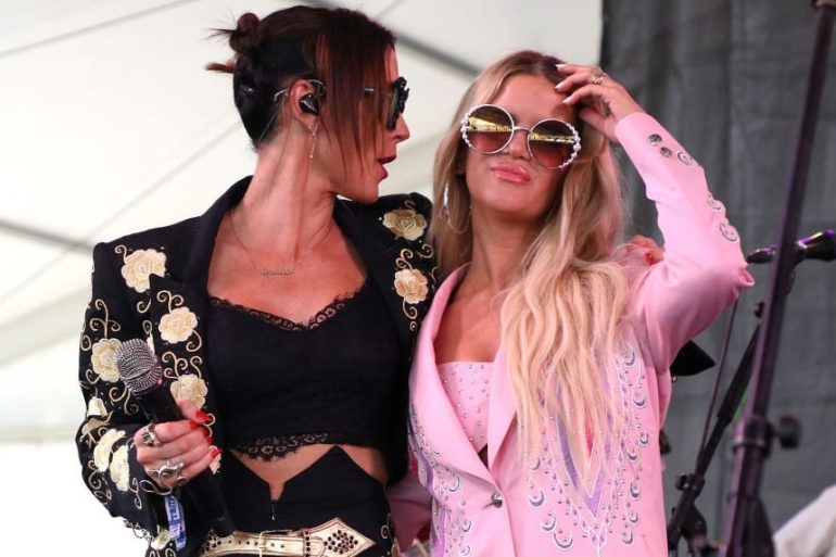 Two women with sunglasses and a microphone