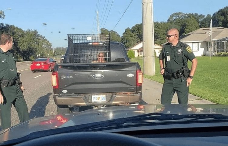 A police officer standing next to a truck