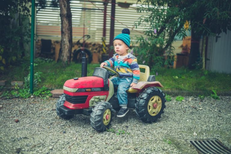 A child riding a toy tractor