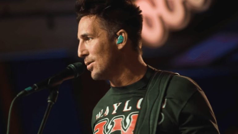 Jake Owen with green eyes and a green shirt with his mouth open