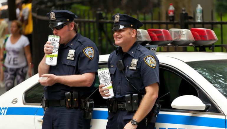 Police officers holding a bottle of alcohol