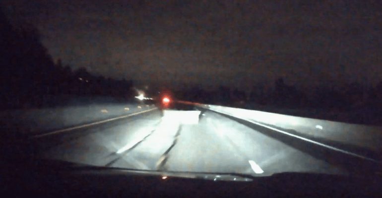 A car driving on a road at night