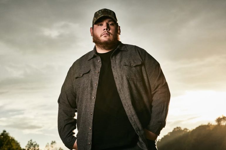 Luke Combs wearing a hat and standing outside