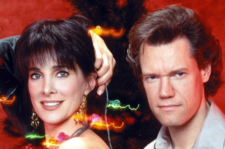Randy Travis, Connie Sellecca are posing for a picture