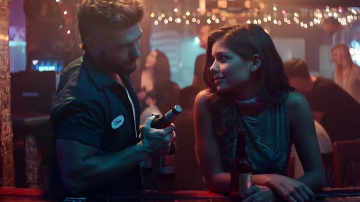 A man and woman talking at a bar