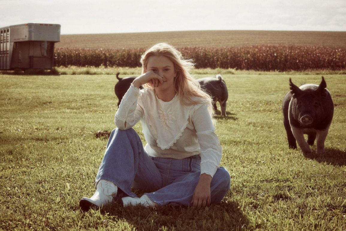 A person sitting in a field with horses