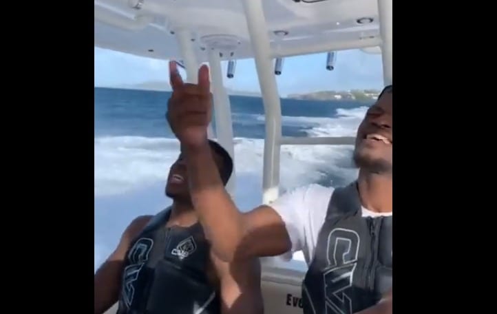A person taking a selfie with a boy on a boat