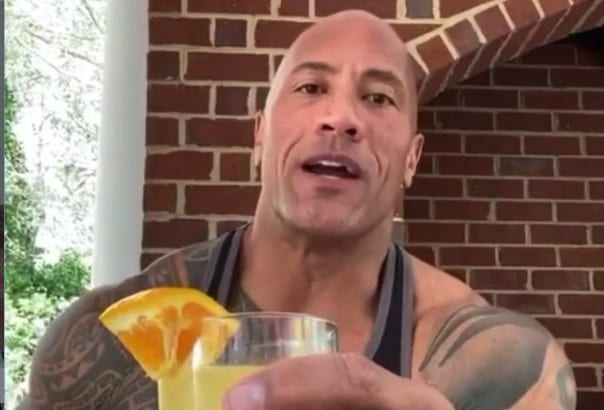 Dwayne Johnson holding a glass of orange juice
