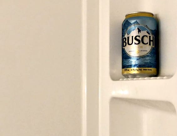 A can of soda on a white wall
