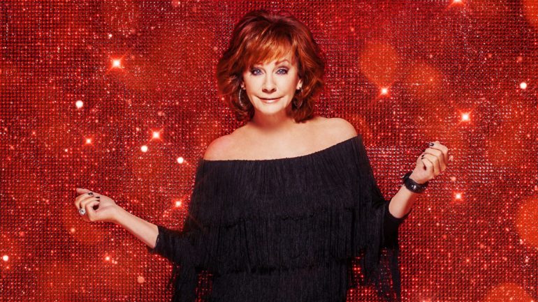 Reba McEntire with her arms out