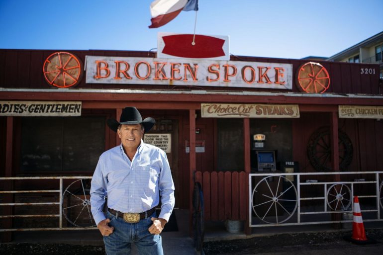 George Strait standing in front of a store