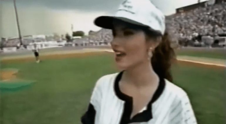 A person wearing a white hat and a white shirt on a baseball field