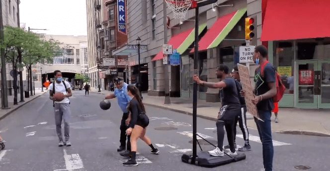 A group of people playing basketball in a street