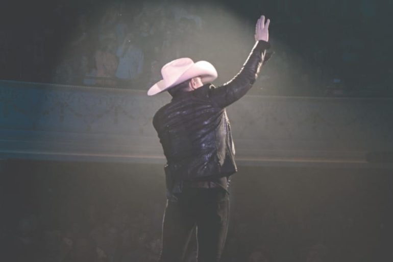 A person wearing a pink hat and holding the hand up