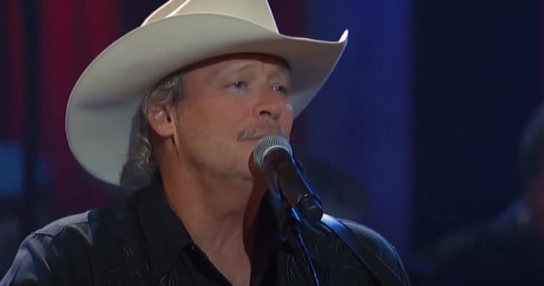 Alan Jackson wearing a white hat and a white hat with a microphone