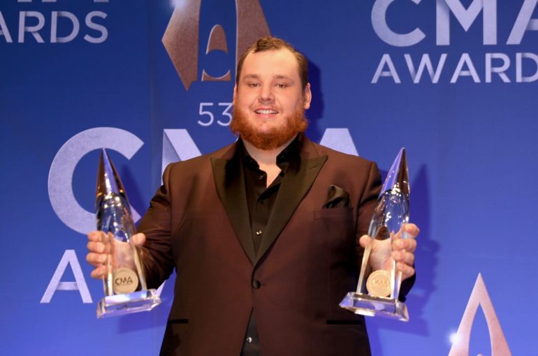 Luke Combs holding a trophy